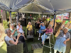 residents under the new canopy enjoying the outdoors whilst with a nice drink