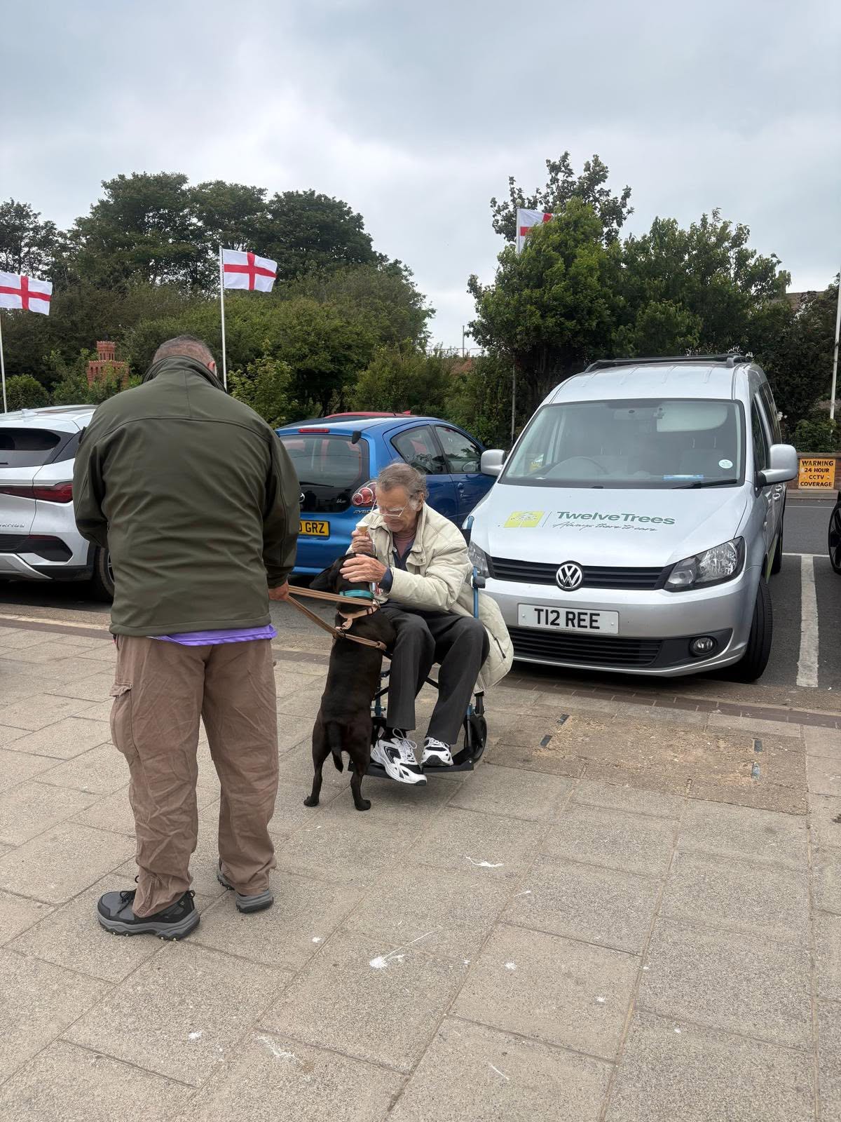 Resident on a day out next to the Twelve Trees Care VW Caddy wheelchair-accessible vehicle