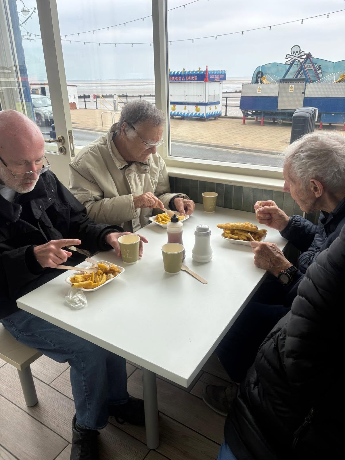 Twelve Trees Care clients enjoying fish and chips at the seaside