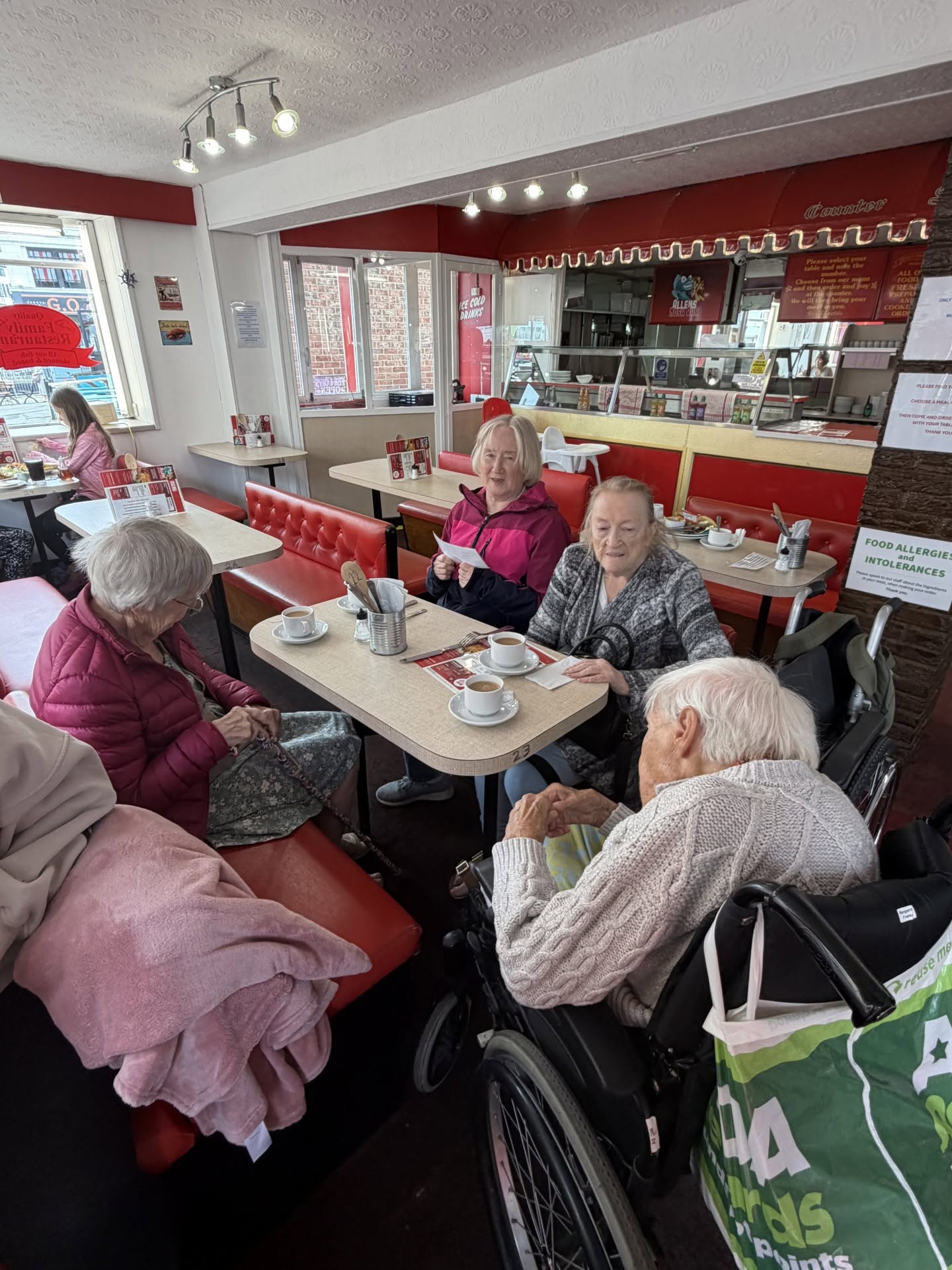 Meadowbrook Manor care home clients having a cup of tea and a chat in a cafe on a day out